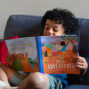Young boy reading a Wonderbook sitting on the sofa